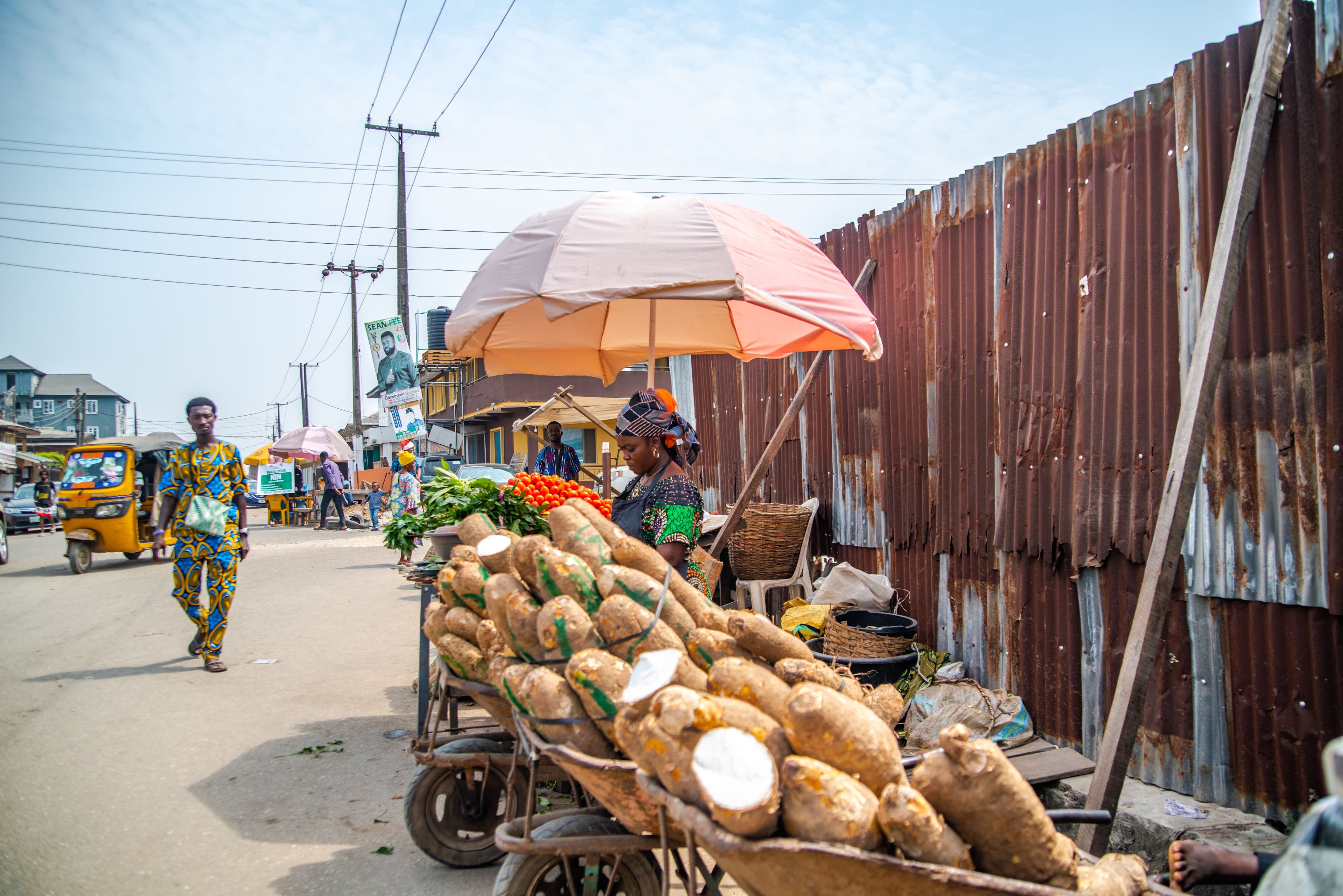 A business owner smiling in front of their stall with merchandise.